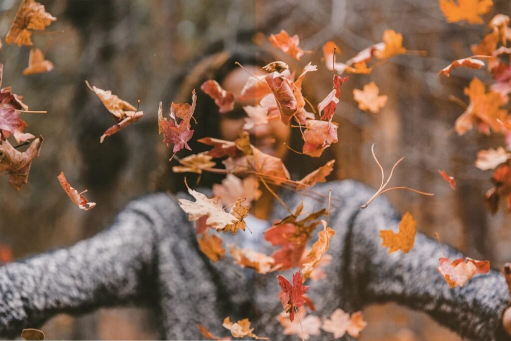 woman throwing autumn leaves