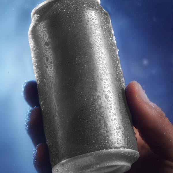A hand holding a gray can with condensation droplets, against a blue background.
