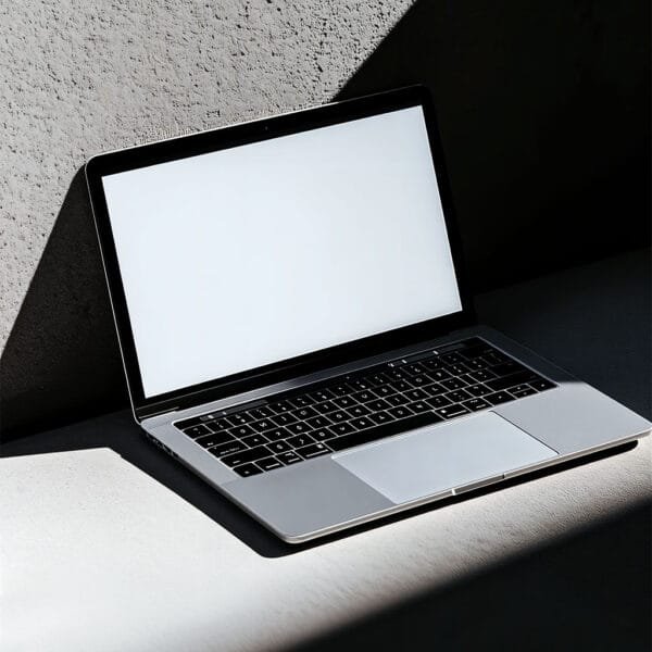 MacBook on a concret wall, har shadow light