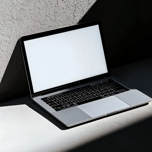 MacBook on a concret wall, har shadow light