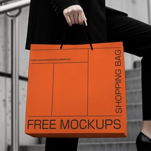 A woman in a black suit and heels holds an orange shopping bag labeled "FREE MOCKUPS" while walking up stairs